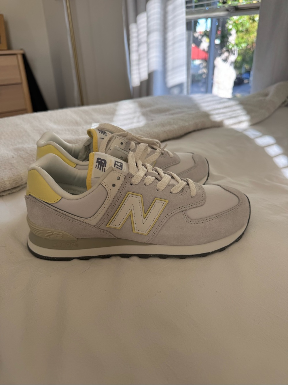 New Balance women’s 574 Sneaker in Light Gray and Pale Yellow